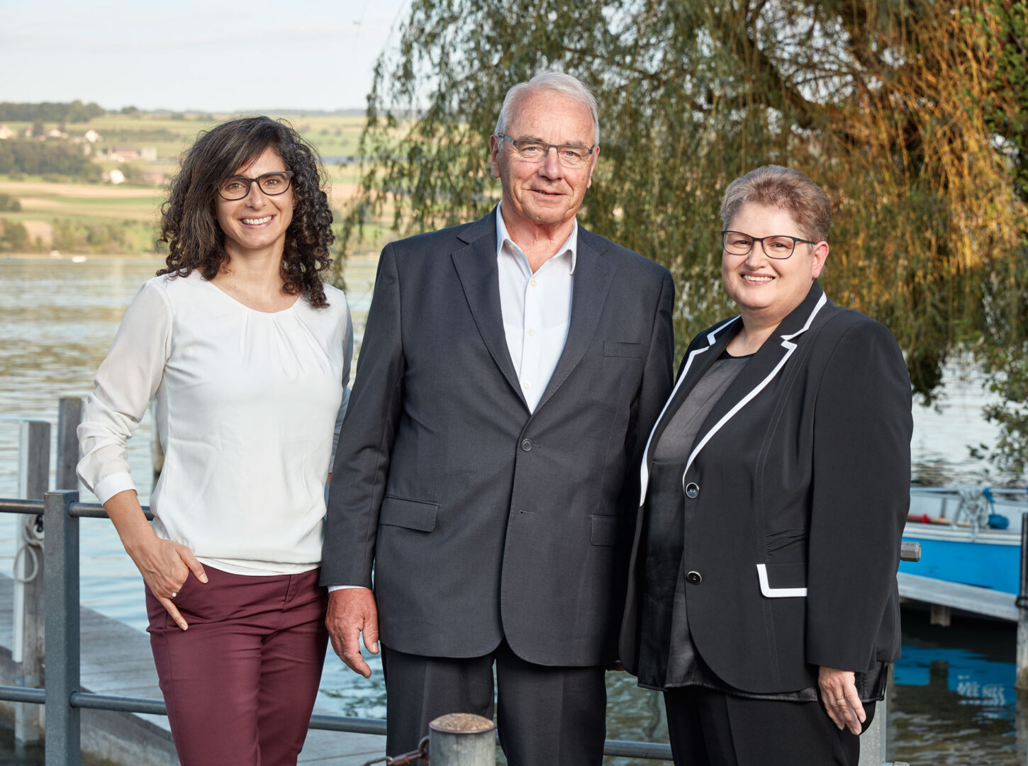 Danièle Turkier, Geschäftsführerin Aarau Standortförderung aus Buchs, Hans Bürge, Unternehmer aus Safenwil und Maja Fabich-Stutz, eidg. dipl. Drogistin aus Sarmenstorf, stehen nebeneinander auf einem Holzsteg vor dem Hallwilersee.